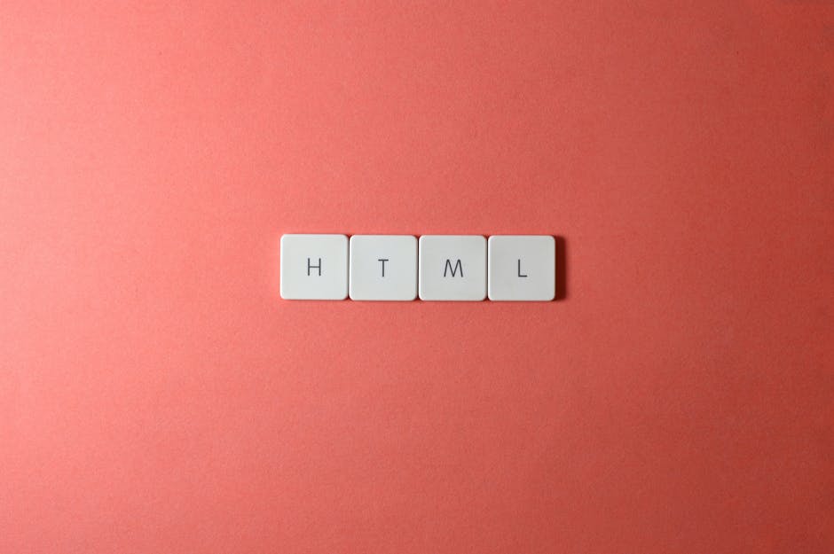 A close-up image displaying four white, rectangular tiles laid in a row on a flat, coral-colored surface. Each tile features a black letter, spelling out 'HTML'. The surface appears smooth with even l